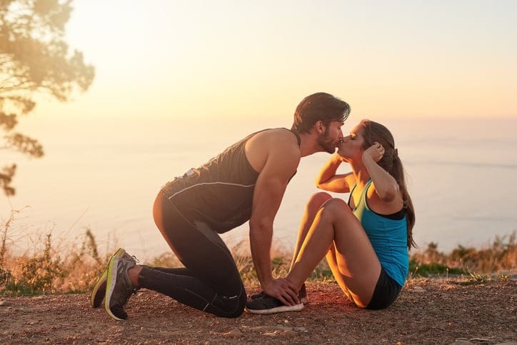 Shot of a young man motivating his girlfriend while she's doing sit ups