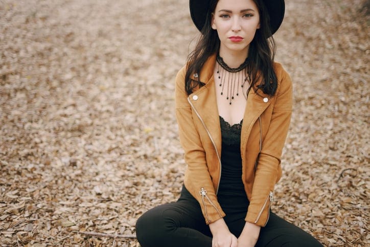 beautiful young model posing in hat on the street