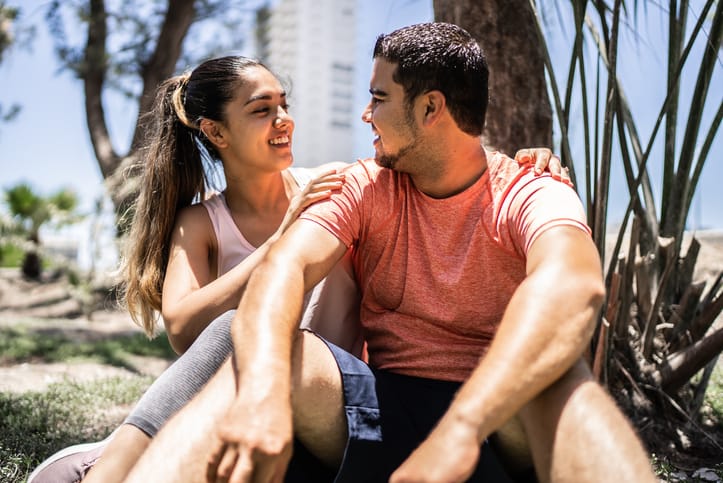 couple smiling in park sunshine