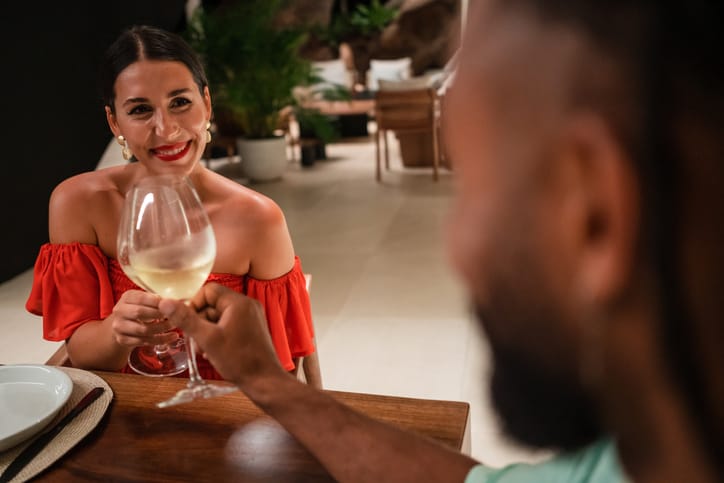 Couple toasting wine on date.
