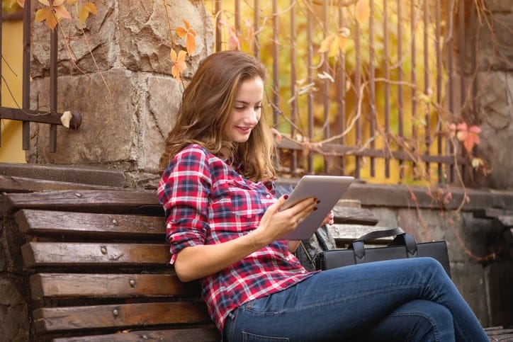 Young woman on the bench with digital tablet