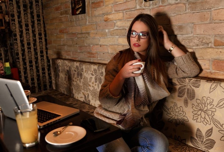 Female student sitting in a cafe and drinking coffee
