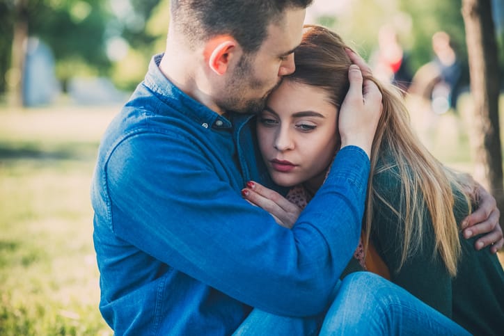 Unhappy young couple in the city park