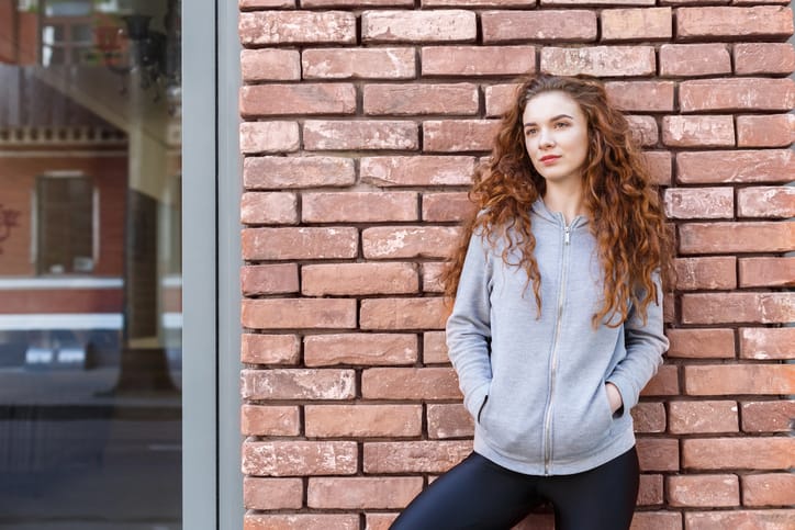 woman alone brick wall city