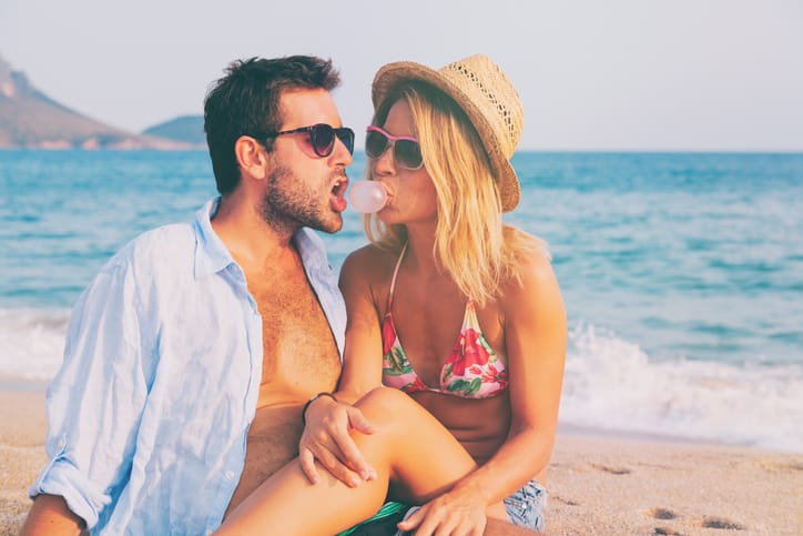 Young couple in love lying on the beach enjoying