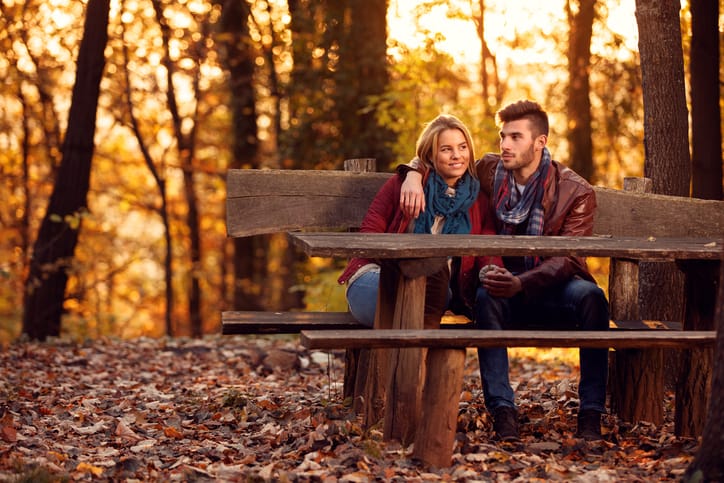 love in the autumn park- Romantic couple on bench
