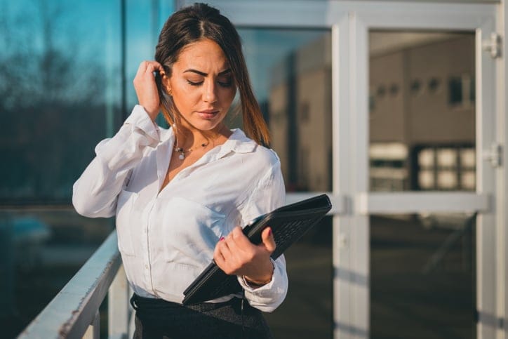 Young formalwear businesswoman carrying digital tablet outdoors