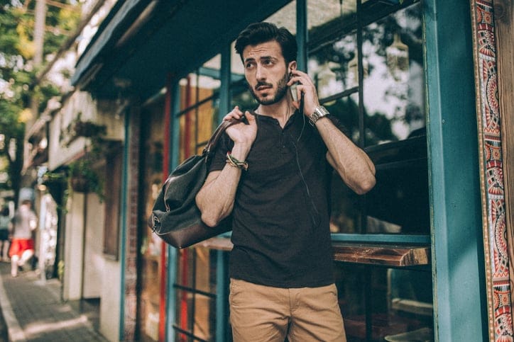 Young man with luggage standing on the street.