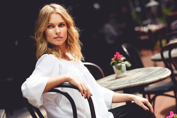 Beautiful blond lady sitting in outdoor cafe on sunny day