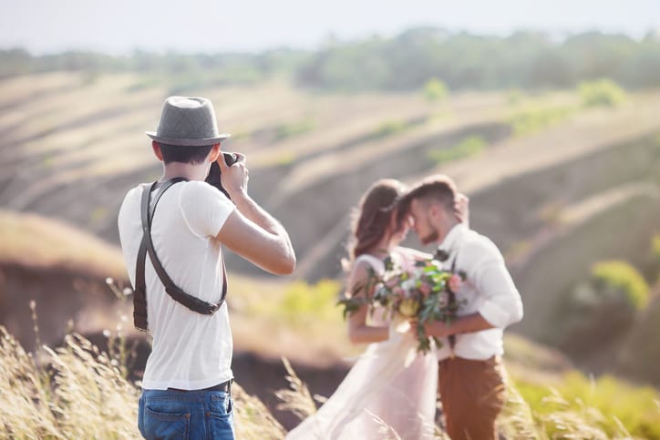 Wedding photographer takes pictures of a bride and groom.