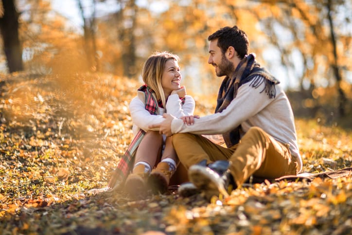 Smiling couple talking while enjoying in their love outdoors.