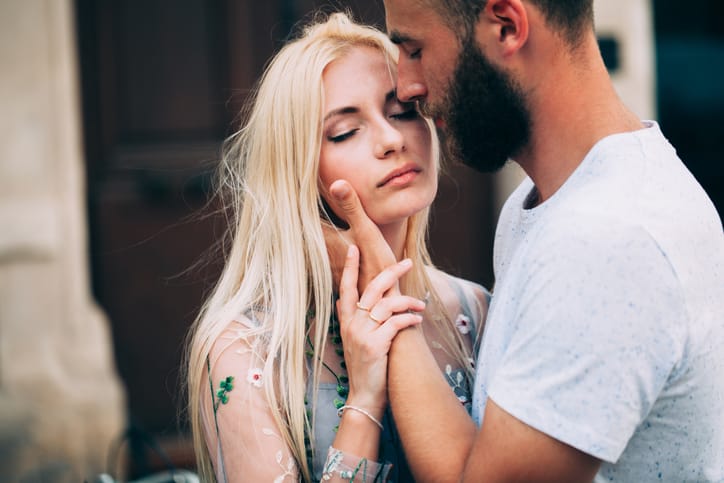 Dating couple kissing and hugging under roses