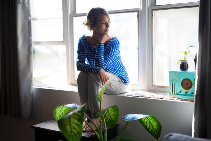 A Beautiful young woman sitting near window
