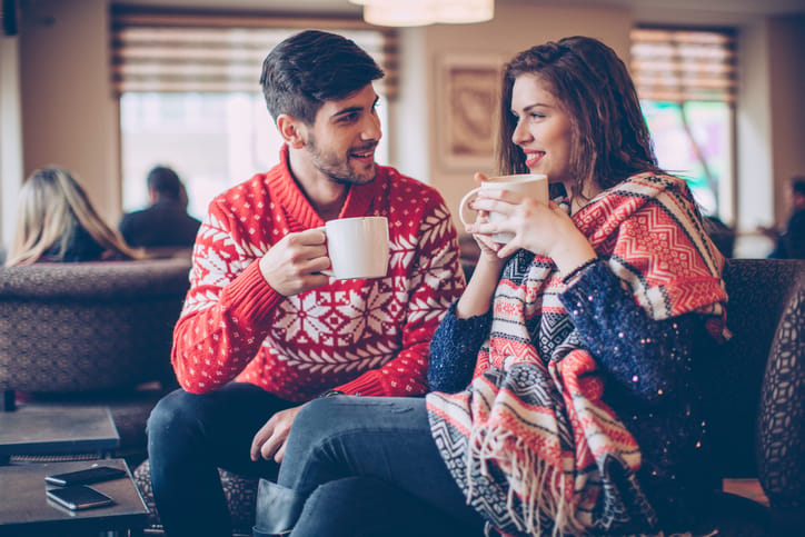 Couple in cafe drinking hot coffee and taking rest from long winter walk