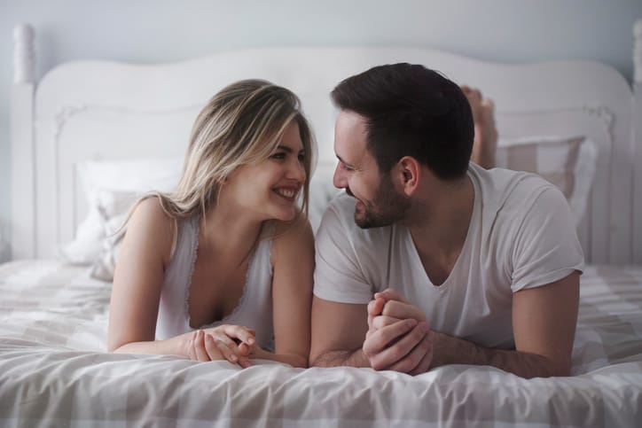 Beautiful woman and attractive man lying on bed together