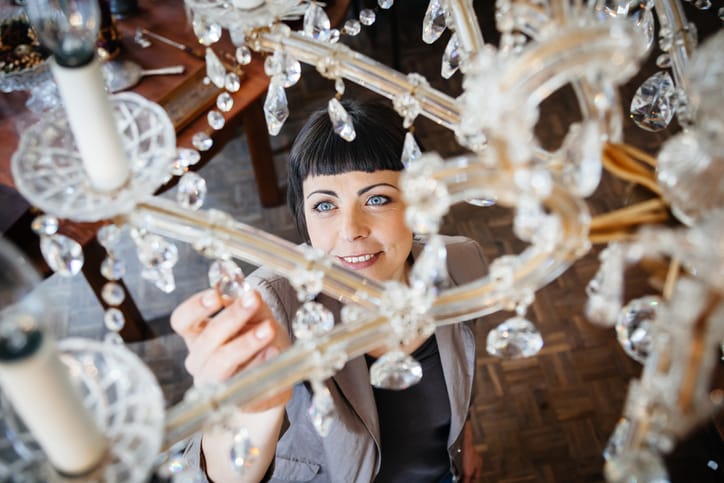 A woman cleaning her chandelier.