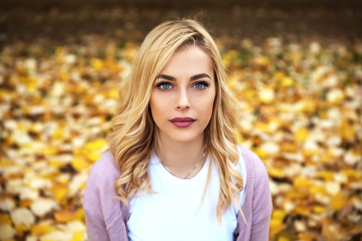 Portrait of beautiful blonde girl sitting in park