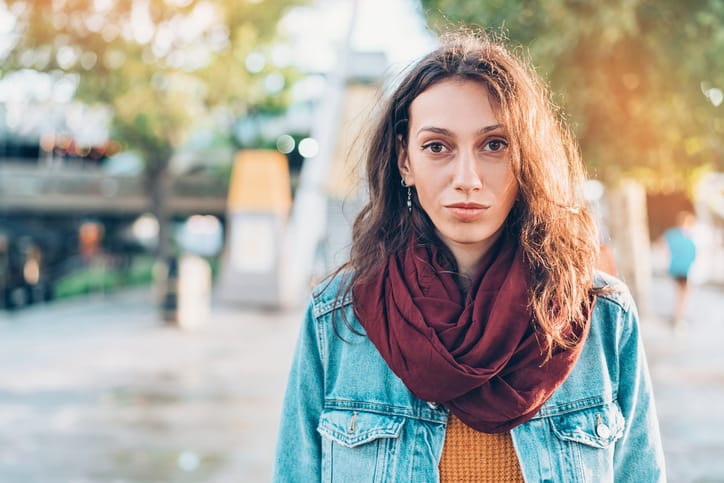 Young woman standing outdoors and looking at camera