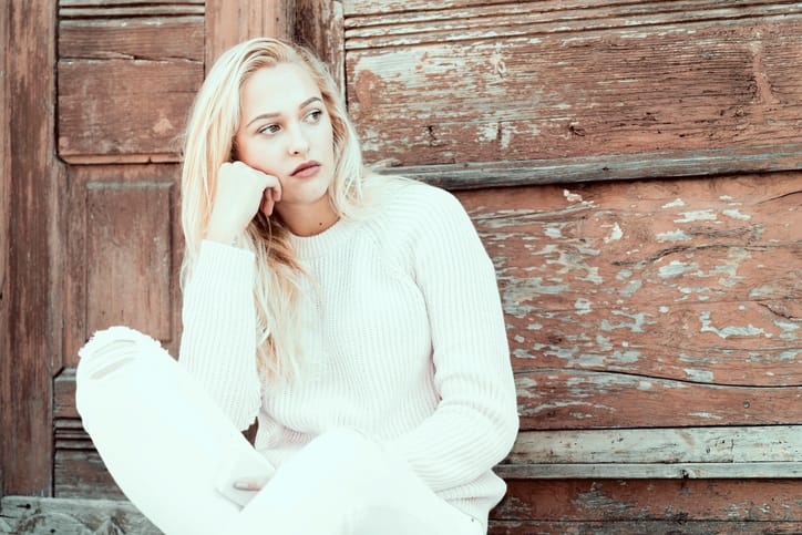 Girl in depression is standing sad on the home stairs