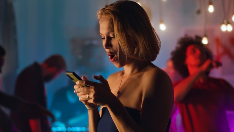 drunk woman texting in a club