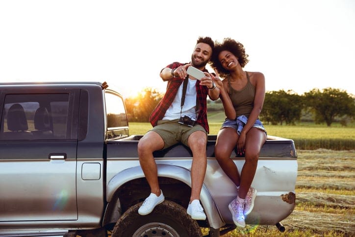 Man and wife on the back of a car.
