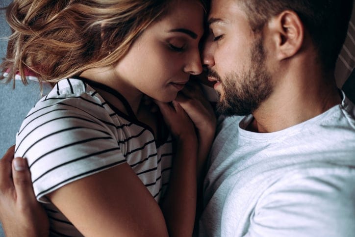 young couple in bed embracing