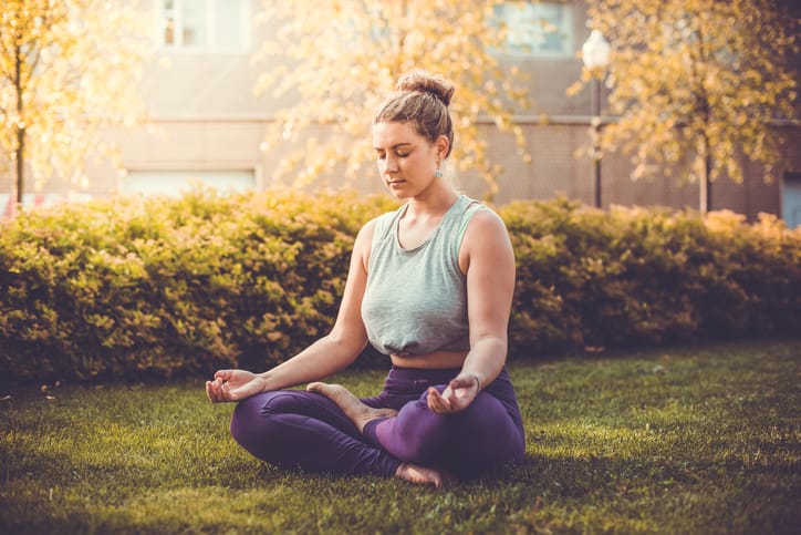 Woman outside doing yoga.