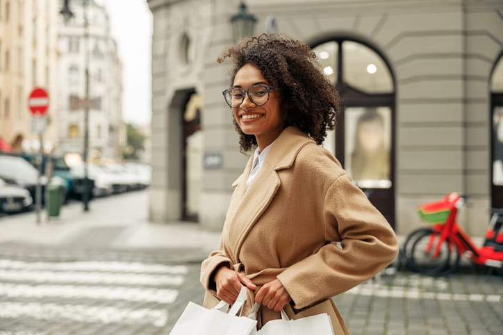 Woman walking in city with shopping bags.