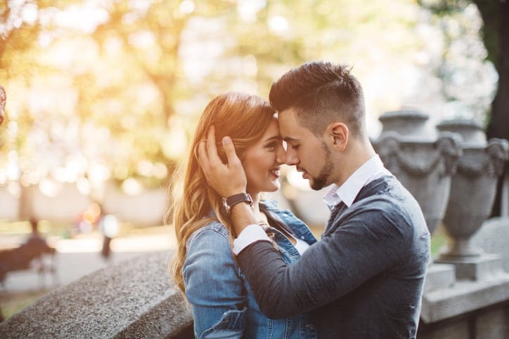Young couple embracing on city streets.