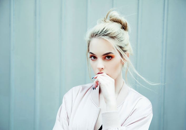 Young blonde woman wearing bomber jacket outdoor portrait