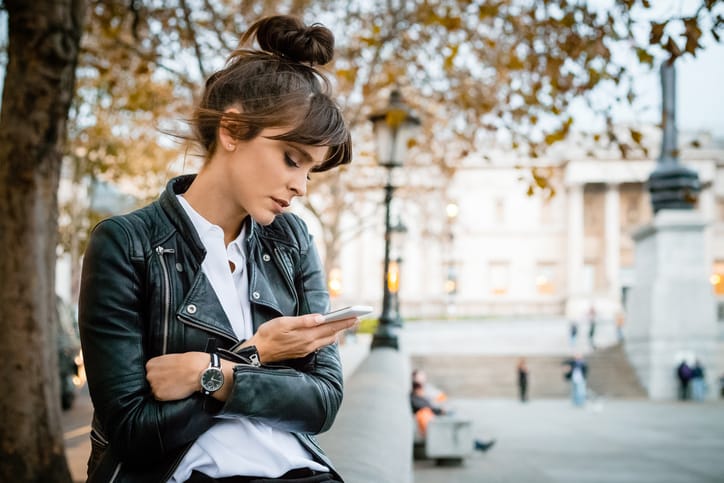 woman in leather jacket texting