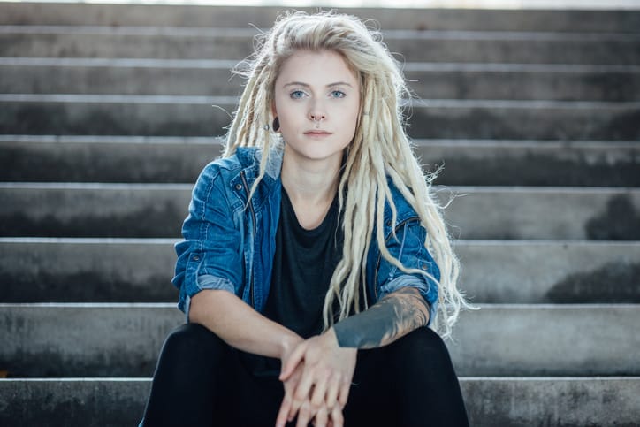 Portrait of young tattooed women sitting on urban staircase