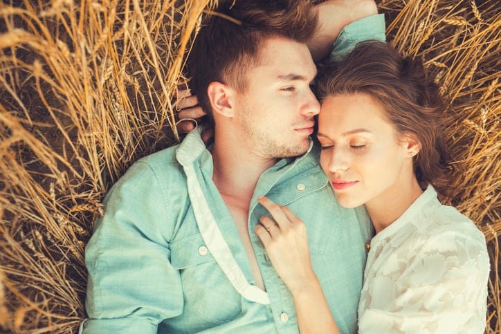 Beautiful couple lying on the glass. Young couple in love outdoor in summer in field