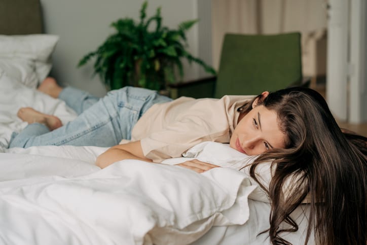 sad woman lounging in bed