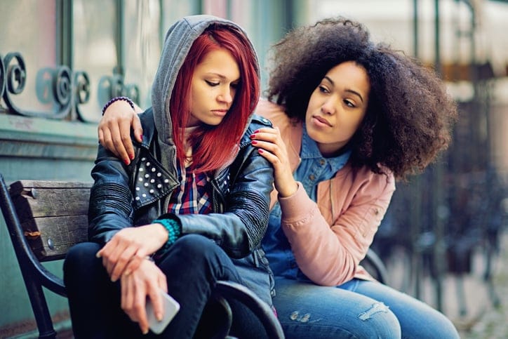Girl consoling her friend.