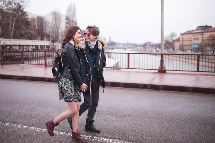 Couple Walking In City Street And Kissing At the Same Time