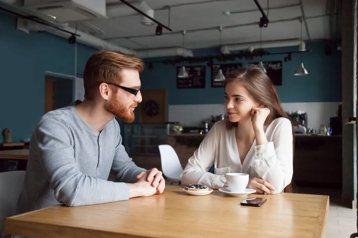 Young guy get acquainted with pretty girl in cafe