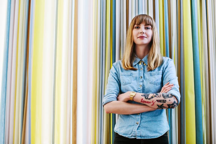 Confident businesswoman against curtain in office