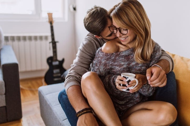 Happy Young Couple Enjoying Free Time On Coffee Break At Home