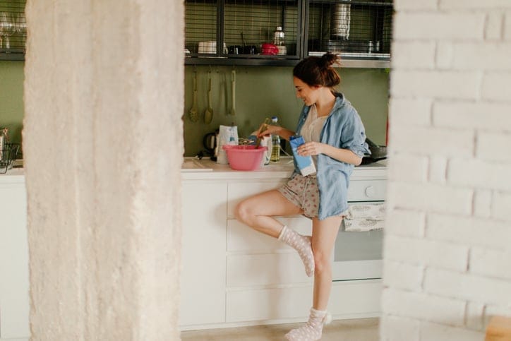 Woman standing in her kitchen.