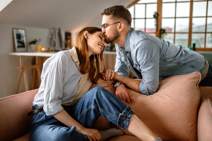 guy kissing girlfriend's forehead