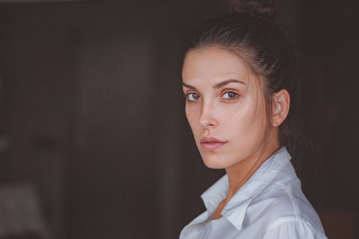 Portrait of a pensive young woman in white shirt
