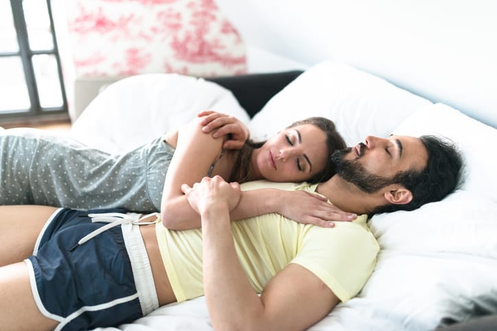 couple relaxing and kissing on the bed