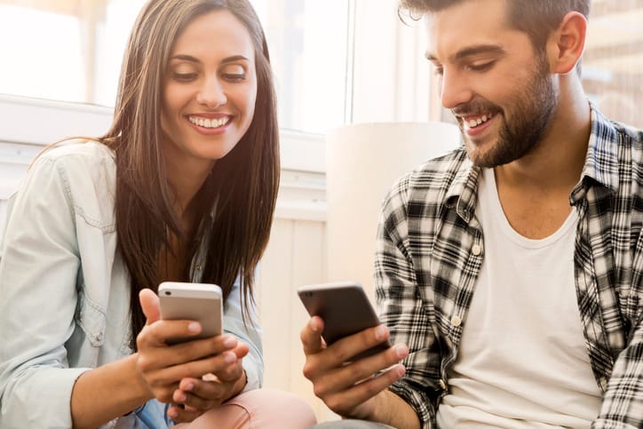 young couple holding mobiles