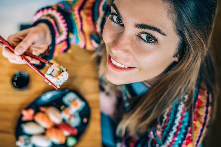 A woman eating sushi.