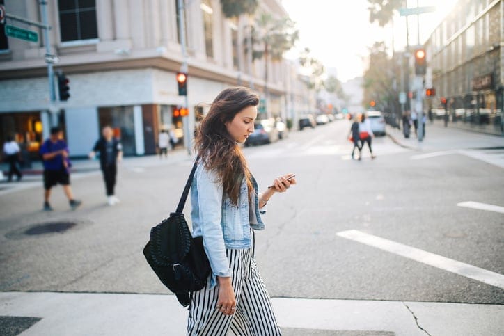 young woman walking across the street
