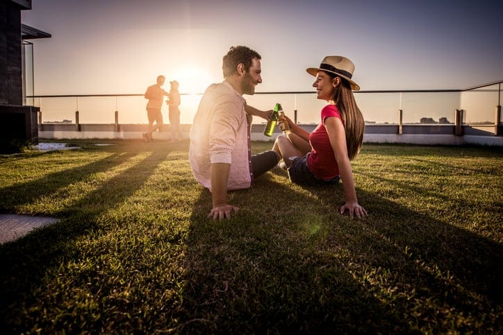 Young couple in love toasting with beer while relaxing on a terrace.