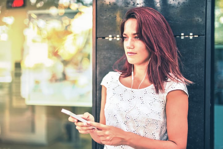 red headed woman holding her smart phone