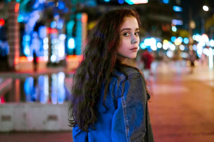 long haired brunette woman looking over shoulder
