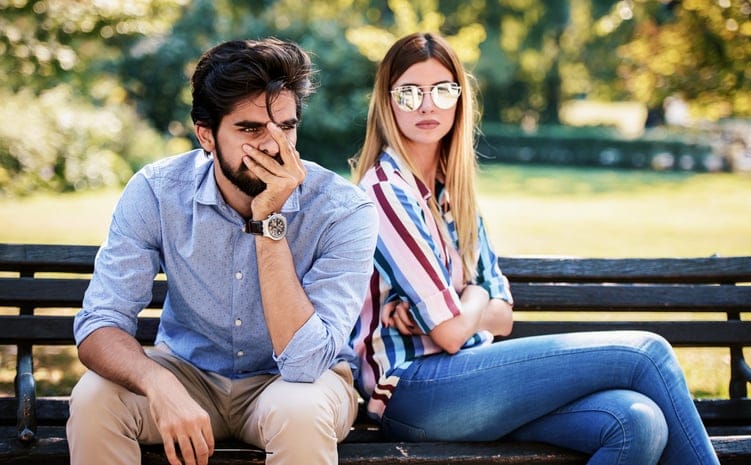 upset couple having fight on park bench